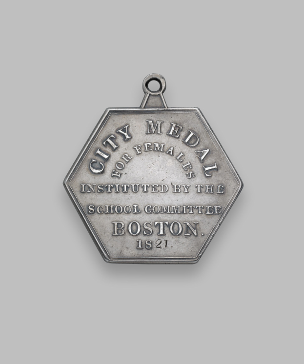 Eine Silbermedaille mit der Inschrift "Stadtmedaille für Frauen" vor einem weißen Hintergrund.