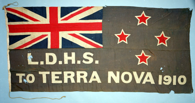 Britisches Flagge mit 'LDHS zu Terra Nova 1910' darauf, das eine Union Jack mit einem weißen Stern in der Mitte zeigt.
