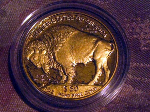 Eine gold- und braune Münze mit der Aufschrift "The United States Of America" darauf, auf einem braunen Teppichhintergrund.