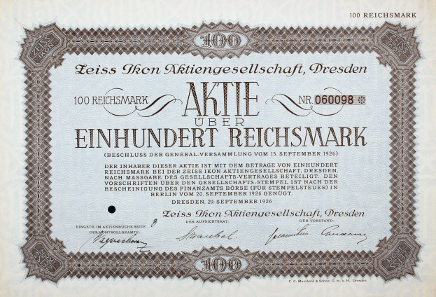 Ein altes deutsches Aktienzertifikat mit schwarzem Rand und der Aufschrift "Aktie über Einhundert Reichmark"