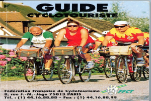 Gruppe von Menschen, die auf Fahrrädern eine Straße entlangfahren, gesäumt von Häusern, Bäumen und Blumen; Text unten lautet "Guide Cyclotouriste".