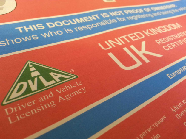 Ein Close-up eines roten und blauen UK-Führerscheins mit der Aufschrift 'DVLA'.
