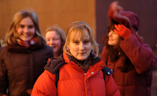 Eine Gruppe von Frauen in Jacken, die zusammenstehen und lächeln.