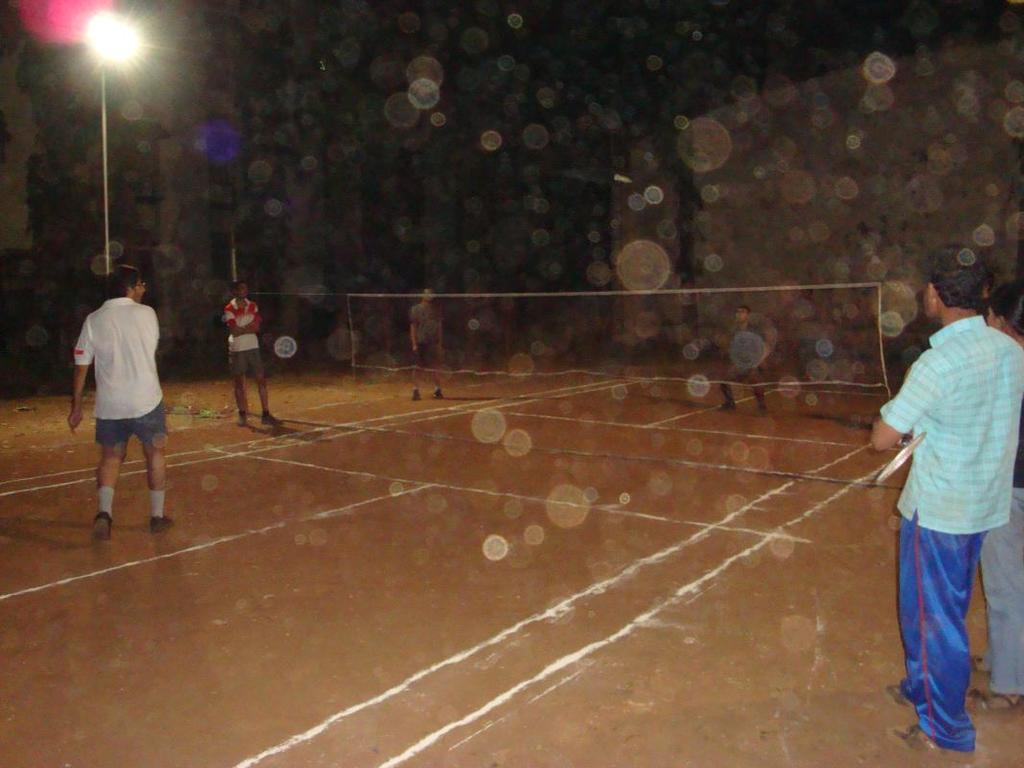 Eine Straßenlaterne steht an der linken Ecke mit ein paar Männern, die Volleyball auf dem Boden spielen.