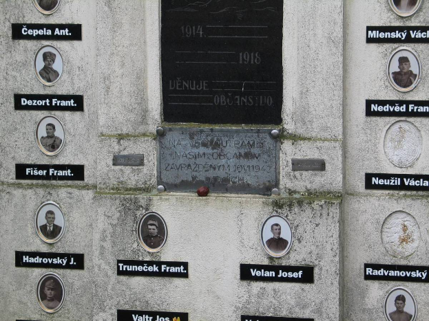 Eine Gedenktafel an einer Wand mit Bildern von Personen und Text, die diejenigen ehrt, die im Zweiten Weltkrieg ihr Leben verloren haben.