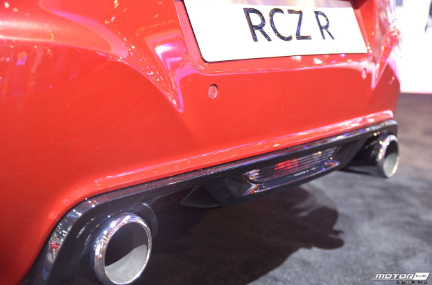 Ein rotes Auto mit einem sichtbaren Nummernschild und einem Wasserzeichen auf der rechten Seite.