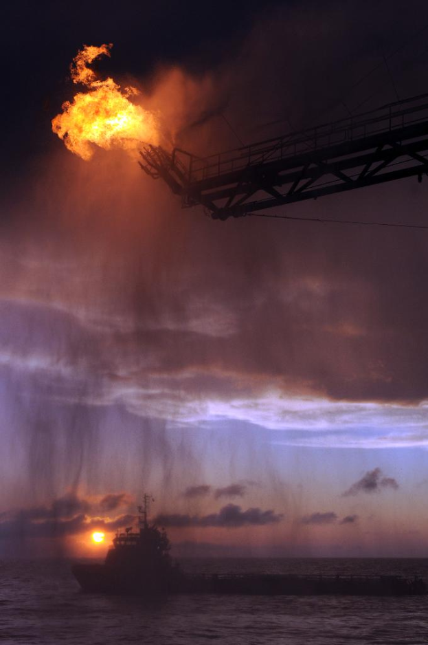 Ein Schiff segelt auf dem Meer unter einem Himmel mit Wolken und einer Sonne, mit einem Feuer auf einem Gestell an der Spitze des Bildes.