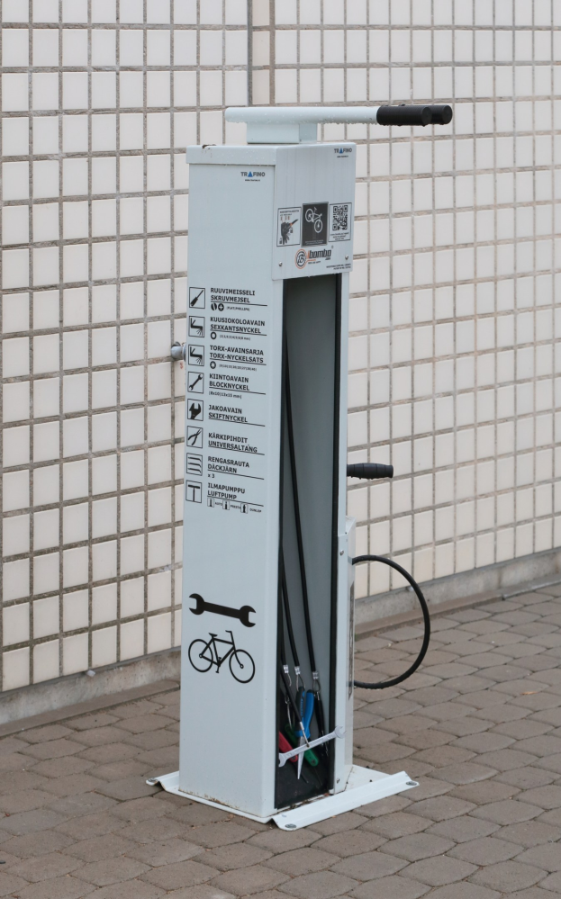 Ladestation für Elektrofahrzeuge mit einem Gerät auf dem Boden neben einem Gebäude.