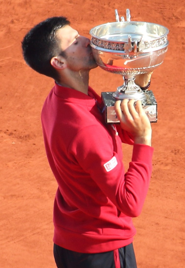 Novak Djokovic hält den French-Open-Pokal und küsst ihn nach seinem Sieg gegen Rafael Nadal im Herrensingelfinale.