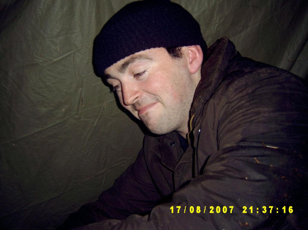 Eine Person in Jacke und Skimütze steht neben einem Blatt.