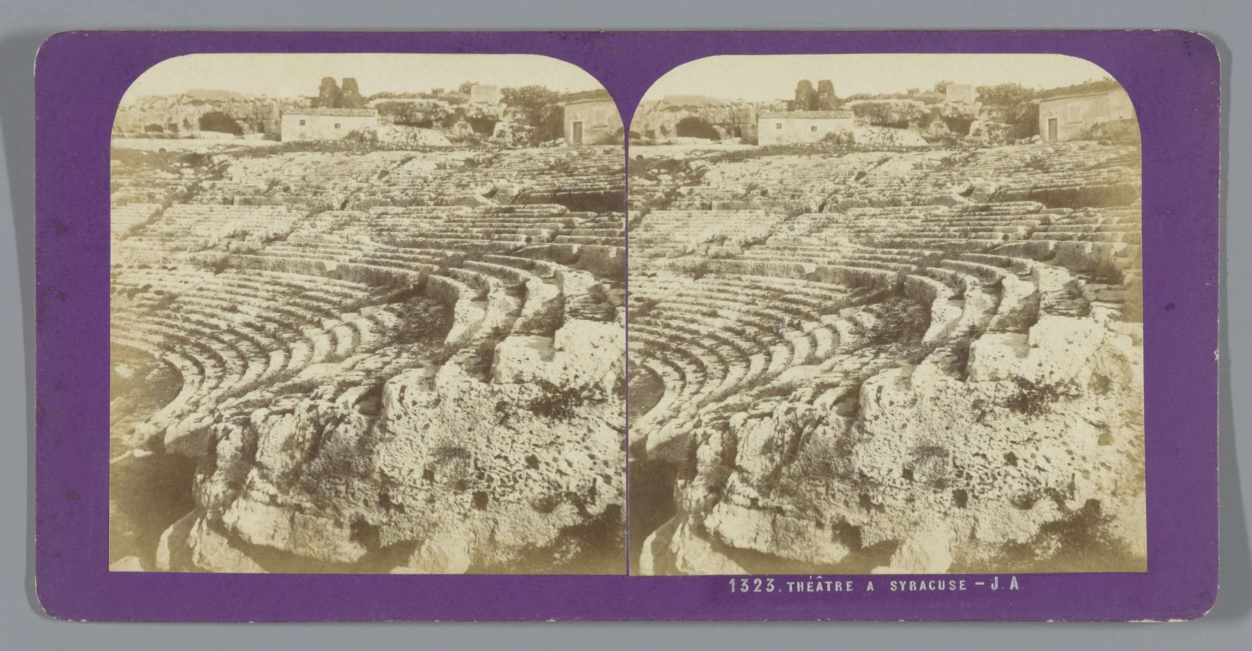 Schwarz-weiß-Stereoskopische Ansichten des antiken Amphitheaters in Syrakus, das Sitzreihen, umgebende Strukturen, Bäume und Himmel zeigt.